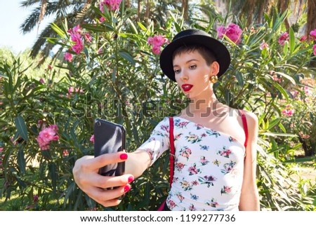 Tourism in Europe, woman taking selfie self-portrait on smartphone on flowers background