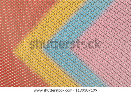 Colorful papers which are red, yellow, blue and pink with partial focus of the grid pattern of paper bin that design as modern background and wallpaper.