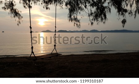 view of wooden  sling on the beach with nice sunset