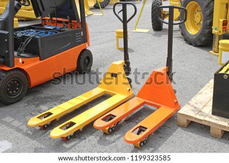 Two Pump Trucks Pallet Jacks Forklifts Royalty-Free Stock Photo #1199323585