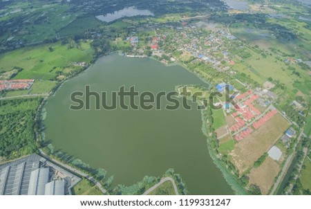 Aerial view morning above the lake, reservoir, green rice fields plantation, factory and villages, Krajub reservoir, Banpong, Ratchaburi, Thailand.