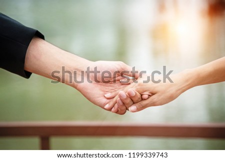 The lady hand touch on hand of husband,love hand sign,for trust and care,warm light tone,blurry light around