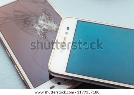 Phones with cracked glasses close-up