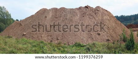 A large pile of construction sand  on forest grassy site. Panoramic collage from several outdoor shots