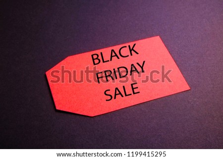 Black friday sale concept. Fourth Friday of November, beginning of Christmas shopping season since 1952. Red tag with black text on bright red background. Copy space, close up, top view, flat lay.