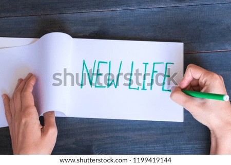 Words New life written in a notebook on the wooden table. 