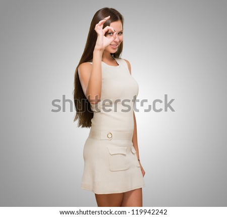 Young Woman Looking Through Imaginary Binocular against a grey background