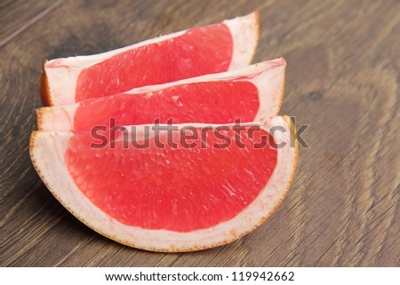 Vegetarian food as a sliced fresh pink grapefruit on a wooden background