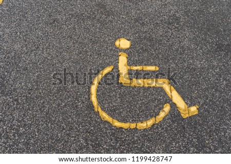 Old Handicapped symbol on parking space, Yellow signs for the disabled on the asphalt parking lot.