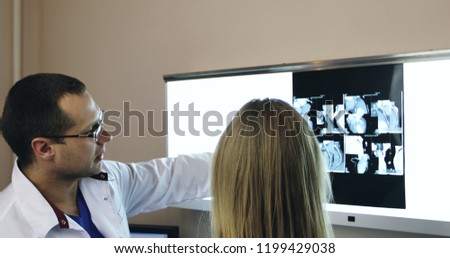 Healthcare, medical: Two doctors discussing and looking x-ray picture in a clinic or hospital.