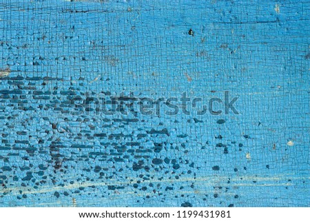 The blue wooden texture with natural pattern. Abstract concept of split, dissent, disagreement, discord, old age, time, separation. Cracked paint with plenty of small cracks.