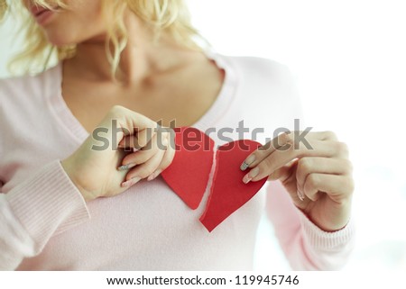 Pretty female showing red broken paper heart