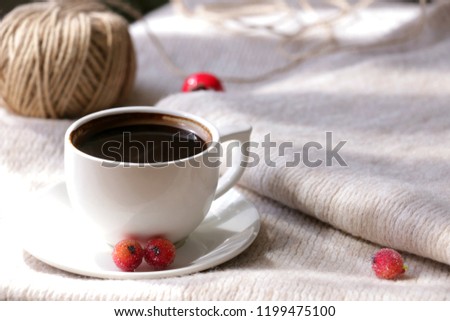 Autumn composition. Cup of hot coffee, big thread ball and berry elements  on cozy background. Royalty-Free Stock Photo #1199475100