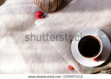 Autumn composition. Cup of hot coffee, big thread ball and berry elements  on cozy background. Royalty-Free Stock Photo #1199475112