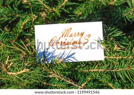 Xmas greeting card with text Merry Christmas and happy new year on christmas tree background.