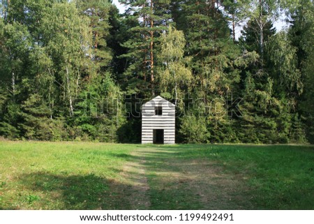 
Photo of an unusual house in the forest, striped building, strange building