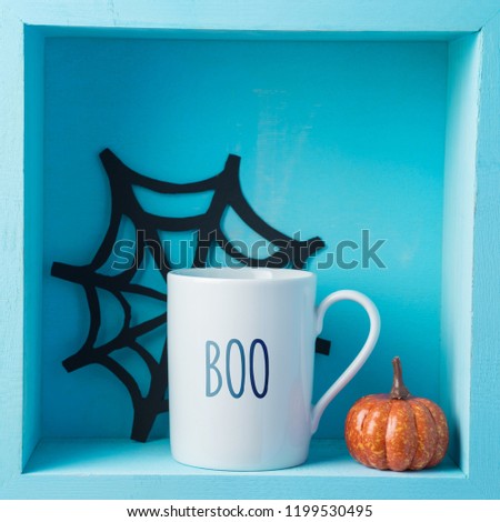 Halloween holiday composition with coffee cup and pumpkin decor on wooden shelf. Minimal concept
