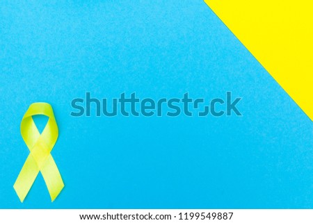 concept of health and medicine. yellow cancer awareness ribbon with trail on blue background.