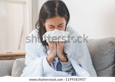 Sick day at home. Asian woman has runny and common cold. Royalty-Free Stock Photo #1199583907