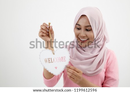 malay woman with tudund holding heart shape object