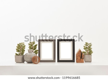 Frame and vase of flowers detail. White decoration on the table and isolated style.