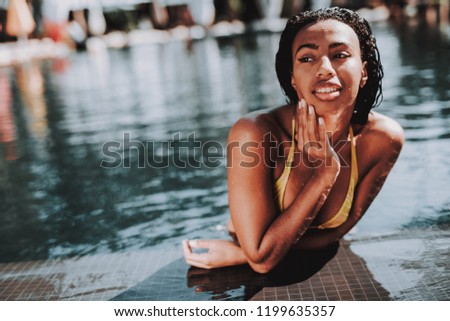 Portrait of Young Black Woman Relaxing in Pool. Beautiful African Girl in Bikini Enjoying Sunny Day at Poolside. Attractive Happy Woman Swimming in Outdoor Hotel Pool. Summer Vacation Concept