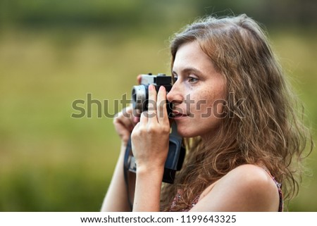 Woman photographer with vintage film camera taking photos outdoor