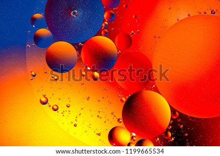Abstract background with yellow, red, purple. Distortion in water with oil droplets. Bright abstraction, ultraviolet. Circles on the water.