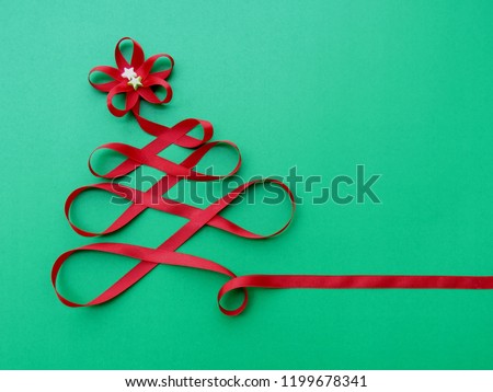 Christmas Tree made of red ribbon on green background for Merry Christmas and New Year Season greeting card, Party invitation friend or family Creative handmade design symbolic image on Happy holidays