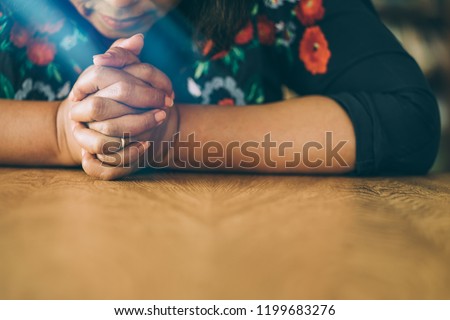 woman praying in the morning.Asian girl hand praying on holy bible in wooden table,Hands folded in prayer concept for faith,spirituality and religion.Vintage tone. Royalty-Free Stock Photo #1199683276