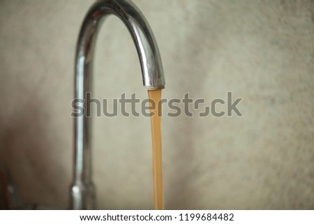 dirty, rusty water flows from the tap Royalty-Free Stock Photo #1199684482