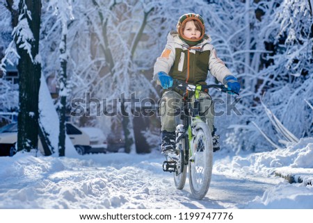 Young boy riding bike in beautiful winter city