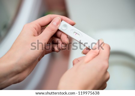 woman holding negative pregnancy test Royalty-Free Stock Photo #119975638