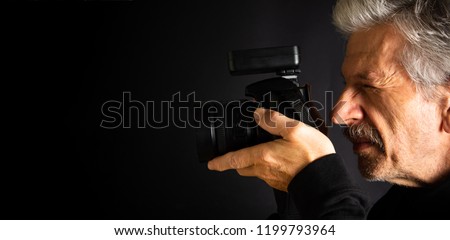 Senior using a DSLR camera close up