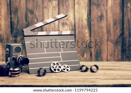 Vintage classic clapperboard and lenses on brown