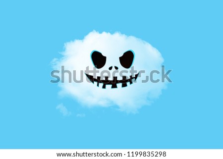 Halloween face on the white cloud on blue background. Halloween minimal concept.