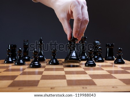 chess move with hand on dark background