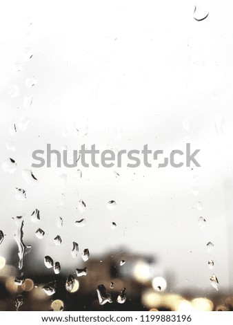 Close up Rain drops on glass window in Street and the city  in bogey background