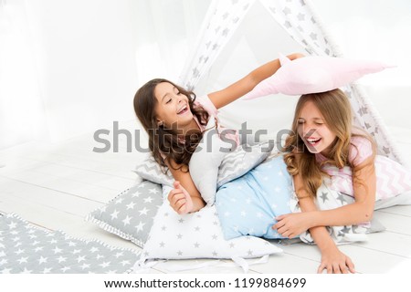 Pajamas party for kids. Girls having fun tipi house. Girlish leisure. Sisters share gossips having fun at home. Cozy place tipi house. Sisters or best friends spend time together lay in tipi house. Royalty-Free Stock Photo #1199884699