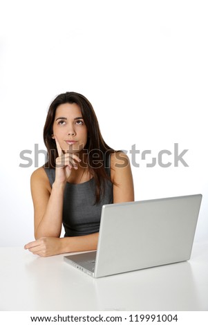 Young woman with thoughtful look in front of laptop