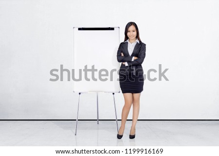 Beautiful asian businesswoman standing with whiteboard on office room