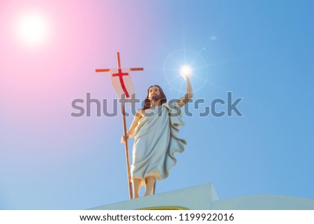 Statue of Jesus.Jesus statue and blue sky,The statue of Jesus holds the cross and the magical light.
