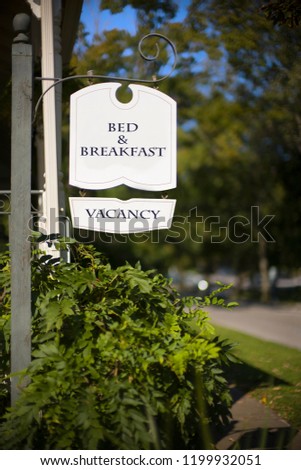 Bed and breakfast wooden signage and surrounding trees