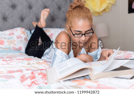 Study Session! School is in and studying can be brutal. Young teenage girl leafs through books while studying in her stylish bedroom.  College or high school student.