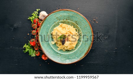 Pasta with Parmesan in the green plate. Italian cuisine. On the old background. Free copy space. Top view.