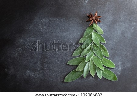 Christmas tree laid out of sage leaves with ornaments and anise star