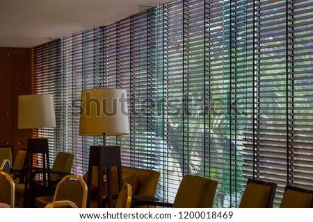 Long blind,jalousie,curtain, Louvers , shade, sunblind, roller, shutter protected sunlight background and glass room. Royalty-Free Stock Photo #1200018469