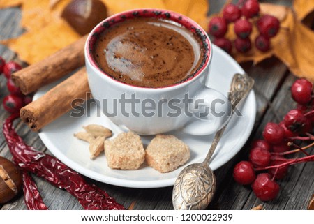A cup of coffee with chili. Hot steaming cup with coffee. Autumn fall leaves.  