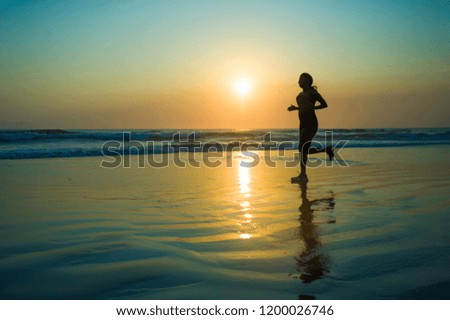 silhouette of young happy and attractive African American runner woman exercising in running fitness workout at beautiful beach jogging and enjoying sunset in health care and outdoors activity 