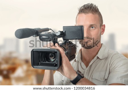 a handsome cameraman with professional camcorder 